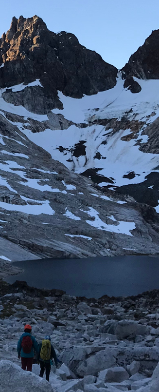 black hiking backpack near white Fujifilm instax mini camera near black leather boots, red half-zip jacket, gray pocket watch on white map
