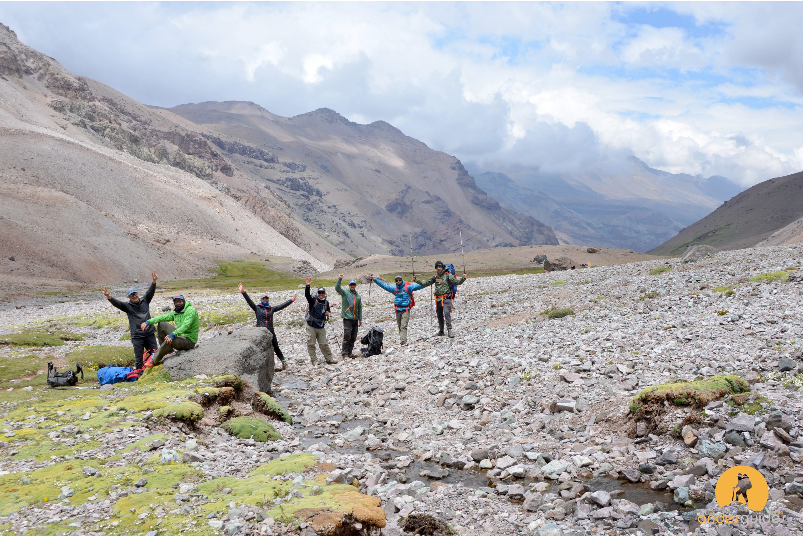 black hiking backpack near white Fujifilm instax mini camera near black leather boots, red half-zip jacket, gray pocket watch on white map