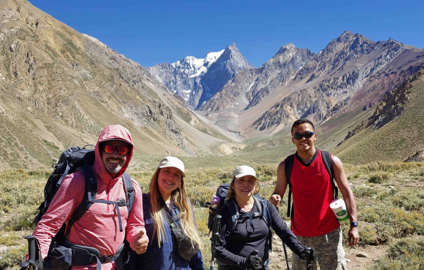 black hiking backpack near white Fujifilm instax mini camera near black leather boots, red half-zip jacket, gray pocket watch on white map