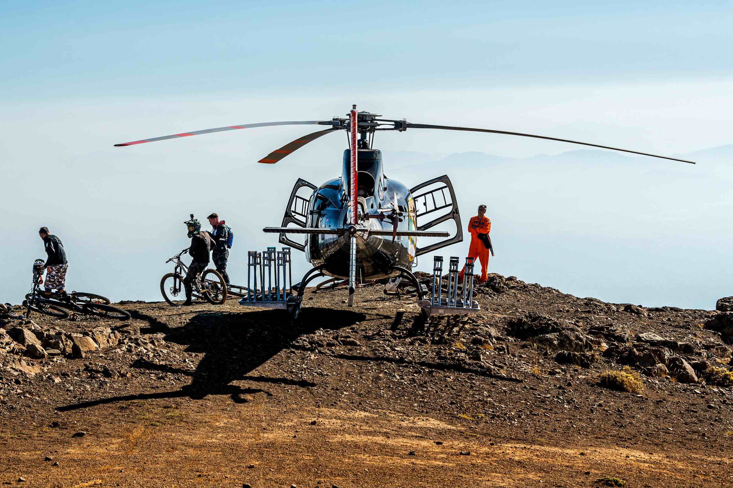 black hiking backpack near white Fujifilm instax mini camera near black leather boots, red half-zip jacket, gray pocket watch on white map
