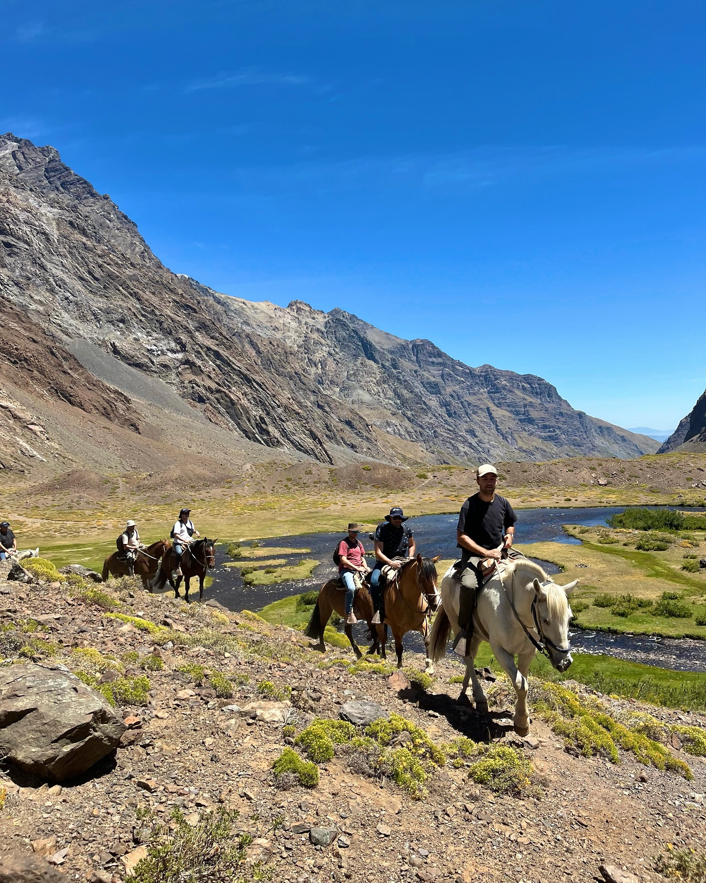 black hiking backpack near white Fujifilm instax mini camera near black leather boots, red half-zip jacket, gray pocket watch on white map