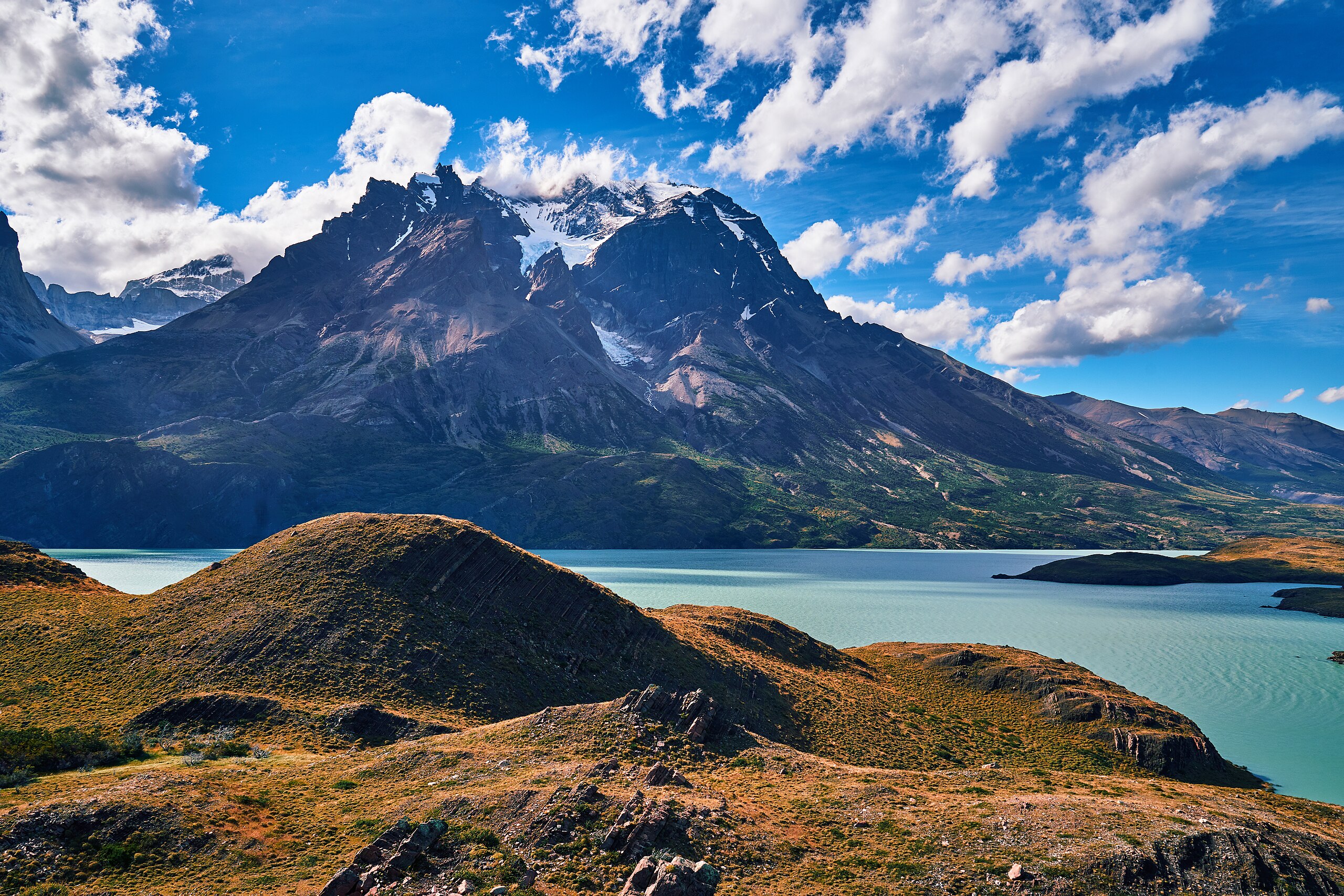 black hiking backpack near white Fujifilm instax mini camera near black leather boots, red half-zip jacket, gray pocket watch on white map