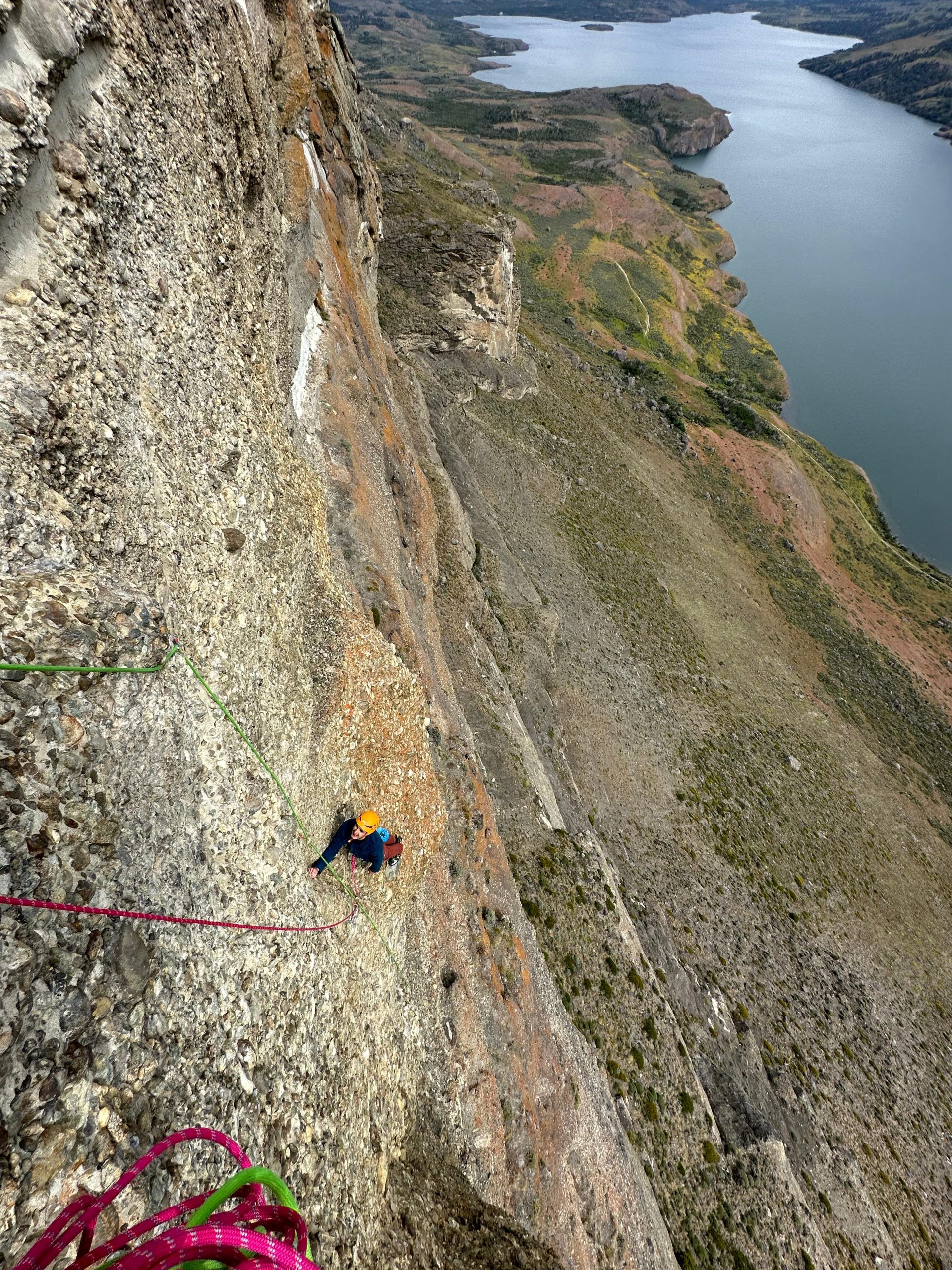 black hiking backpack near white Fujifilm instax mini camera near black leather boots, red half-zip jacket, gray pocket watch on white map