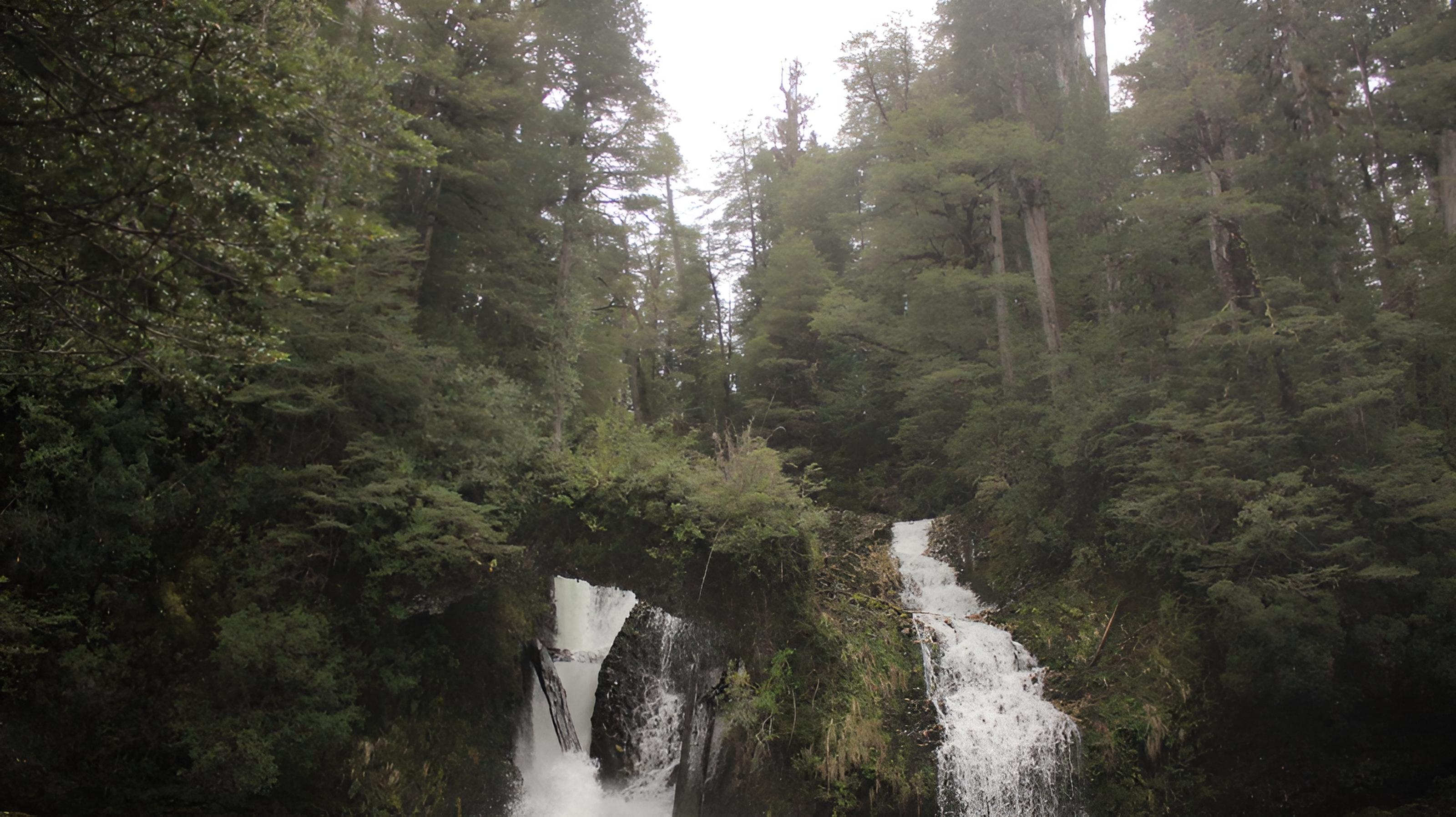 black hiking backpack near white Fujifilm instax mini camera near black leather boots, red half-zip jacket, gray pocket watch on white map